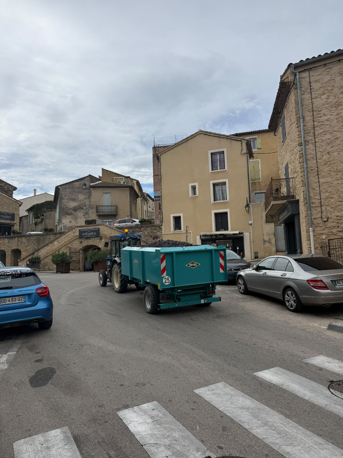 A tractor hauling a trailer of freshly harvested grapes through the village of Châteauneuf-du-Pape during the 2026 harvest.